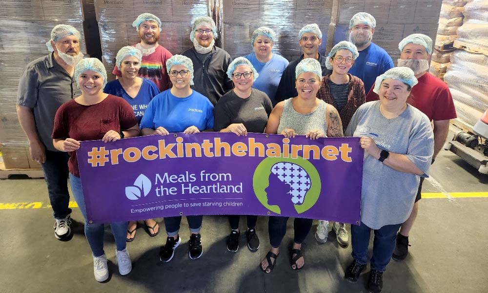 Windsor volunteers hold Meals from the Heartland banner