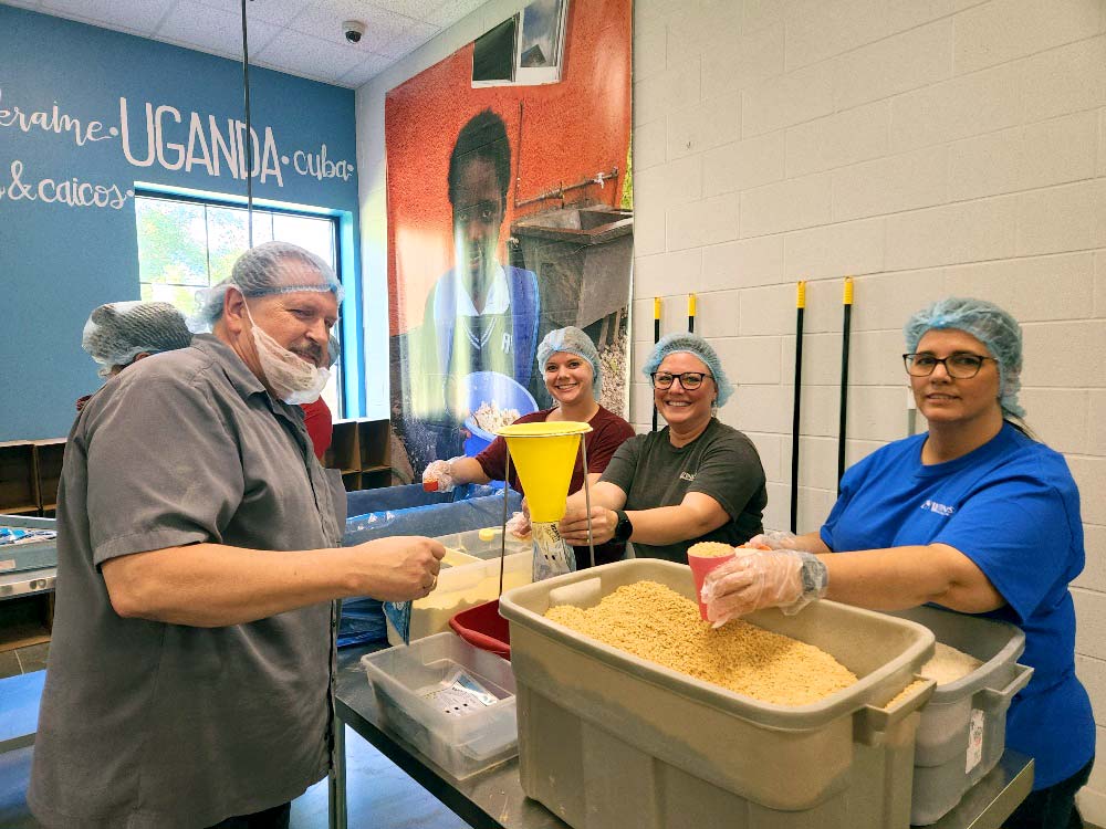 Happy volunteers packing meals from the heartland