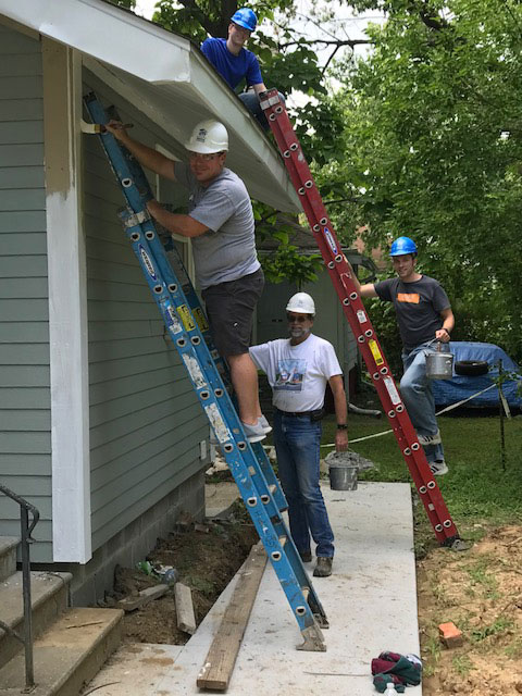 Windsor Team paints home exteriors on a ladder