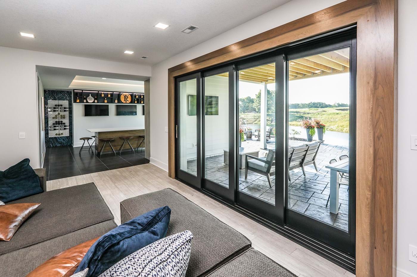 View from interior of home looking out of a sliding patio door onto a patio and open back yard